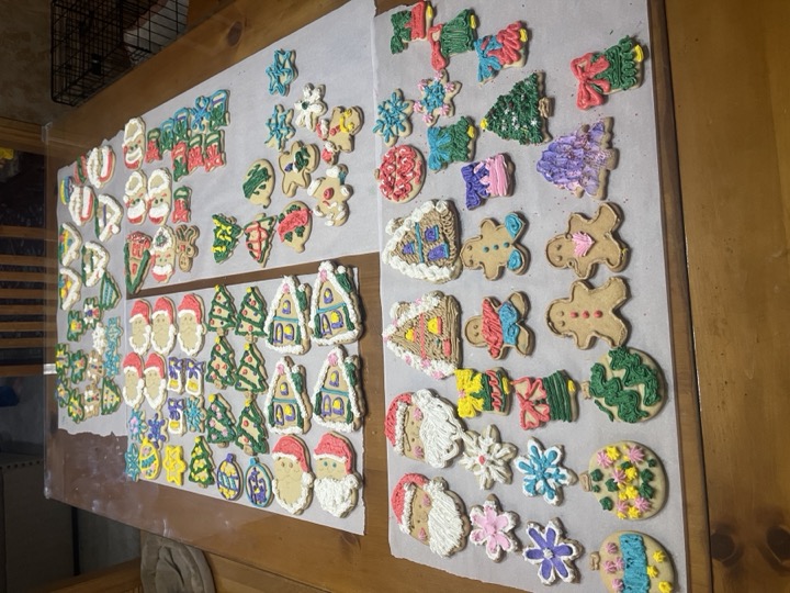Large assortment of decorated Christmas sugar cookies on parchment