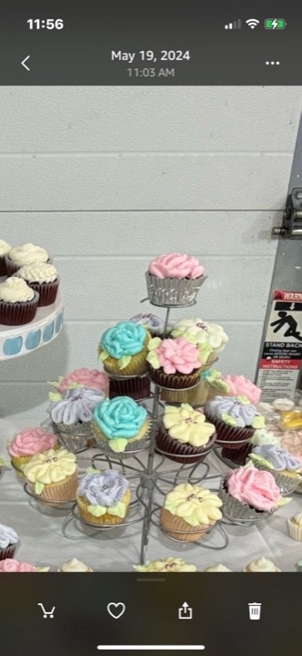 Tiered stand of cupcakes with pink, blue, yellow, and lavender floral frosting
