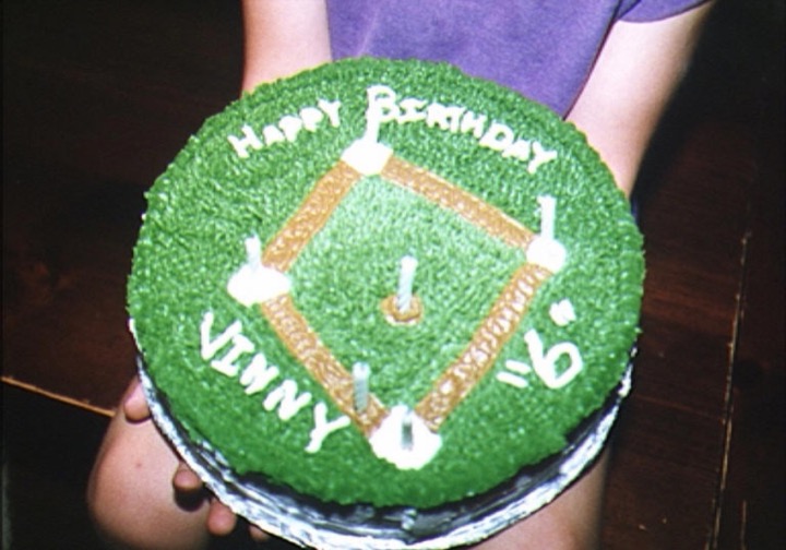 Birthday cake decorated as a baseball field with diamond and candles