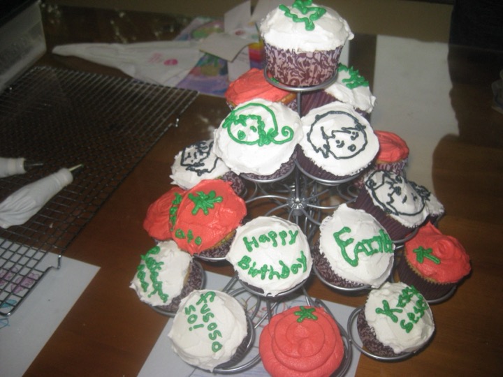 Tiered stand of birthday cupcakes with piped faces and Happy Birthday message