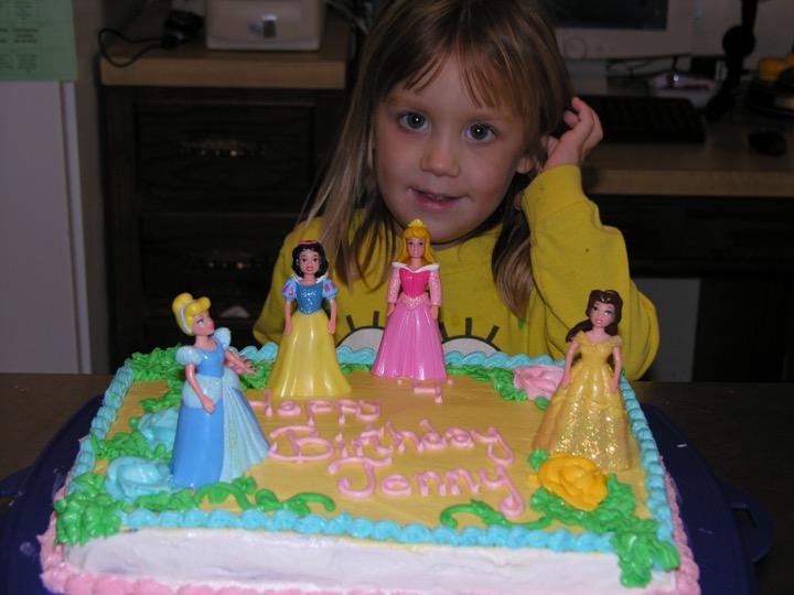 Yellow sheet cake with Disney princess figurines and Happy Birthday piping