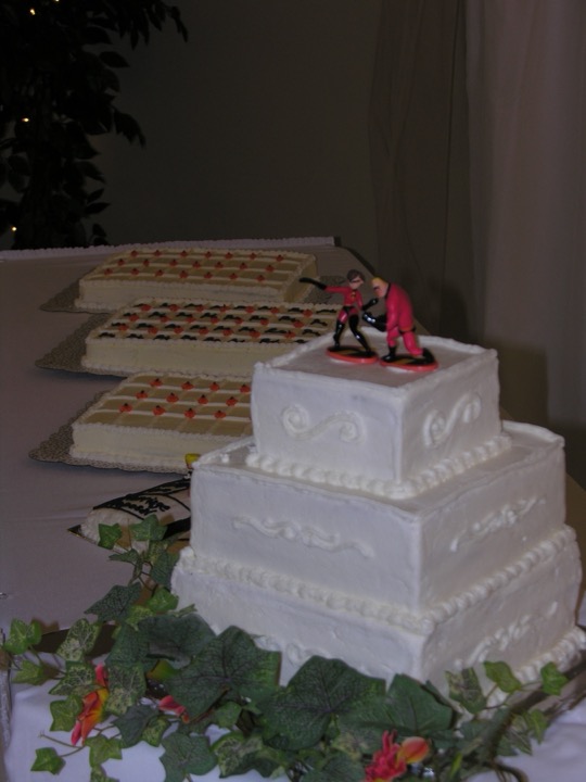 Three-tier square white cake with matching sheet cakes for a large celebration