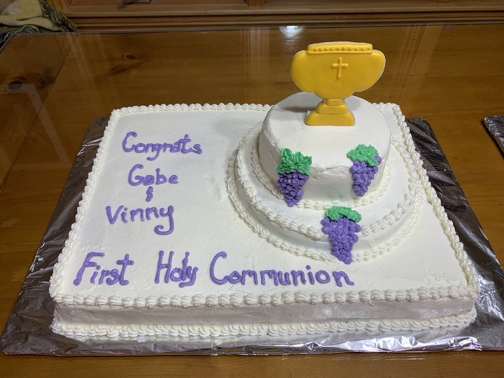 White communion cake with chalice topper, grape accents, and purple lettering