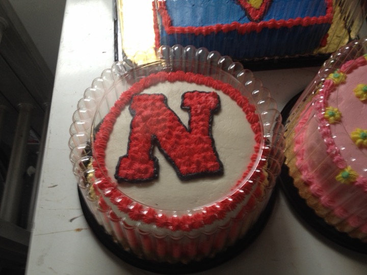 Round white cake with red University of Nebraska N logo