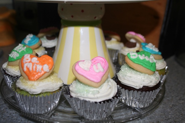 Cupcakes topped with heart cookies reading Be Mine, Sweet, and I love you