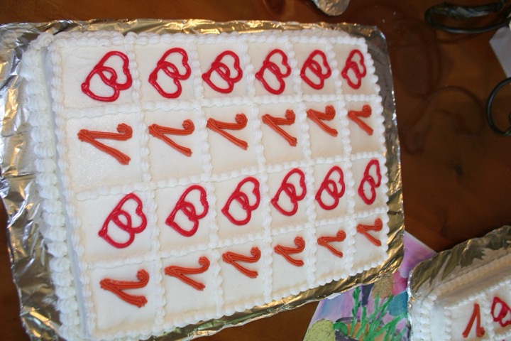 White sheet cake with red interlocking hearts in a piped grid