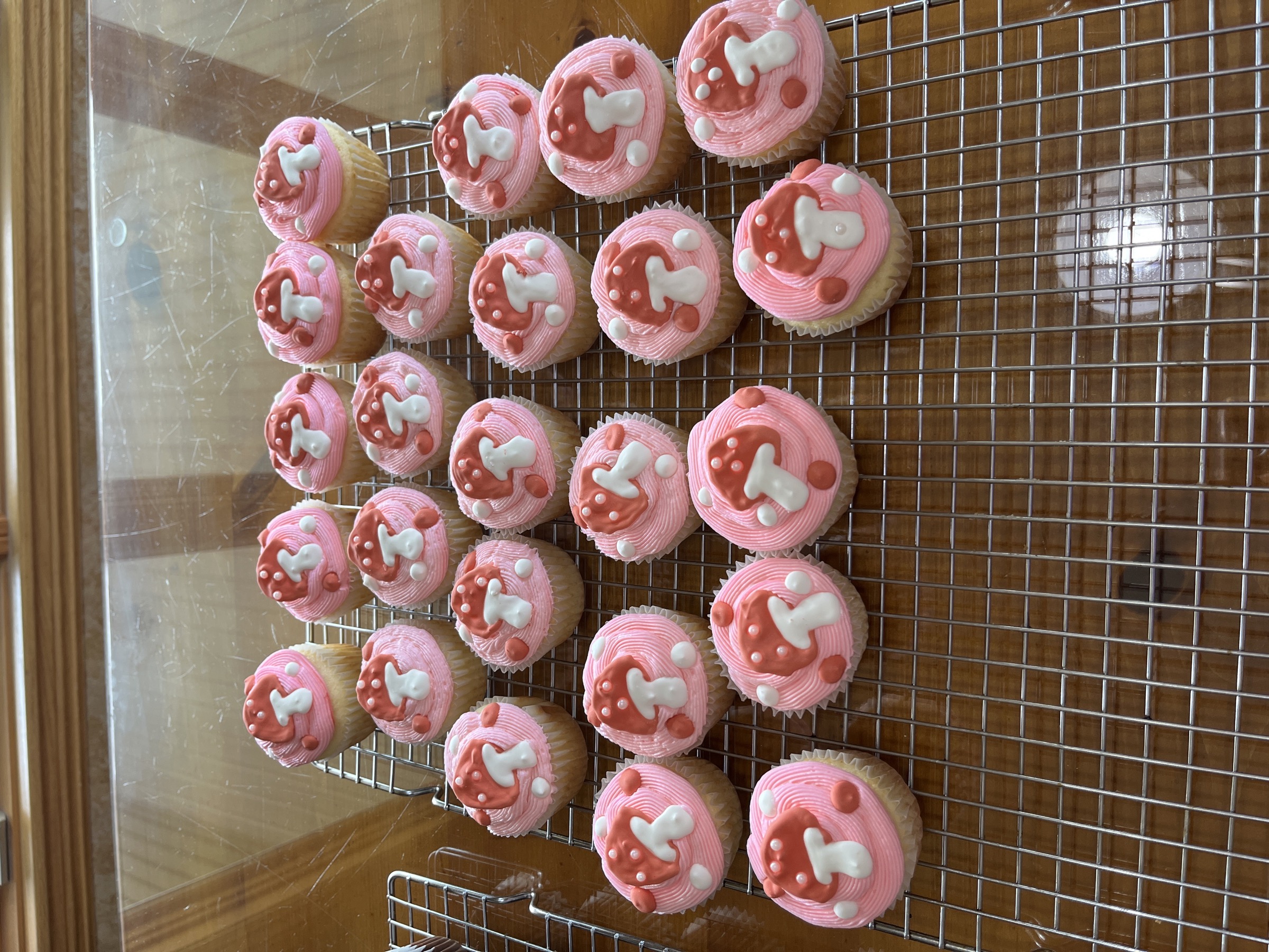 Pink-frosted cupcakes topped with red mushroom decorations
