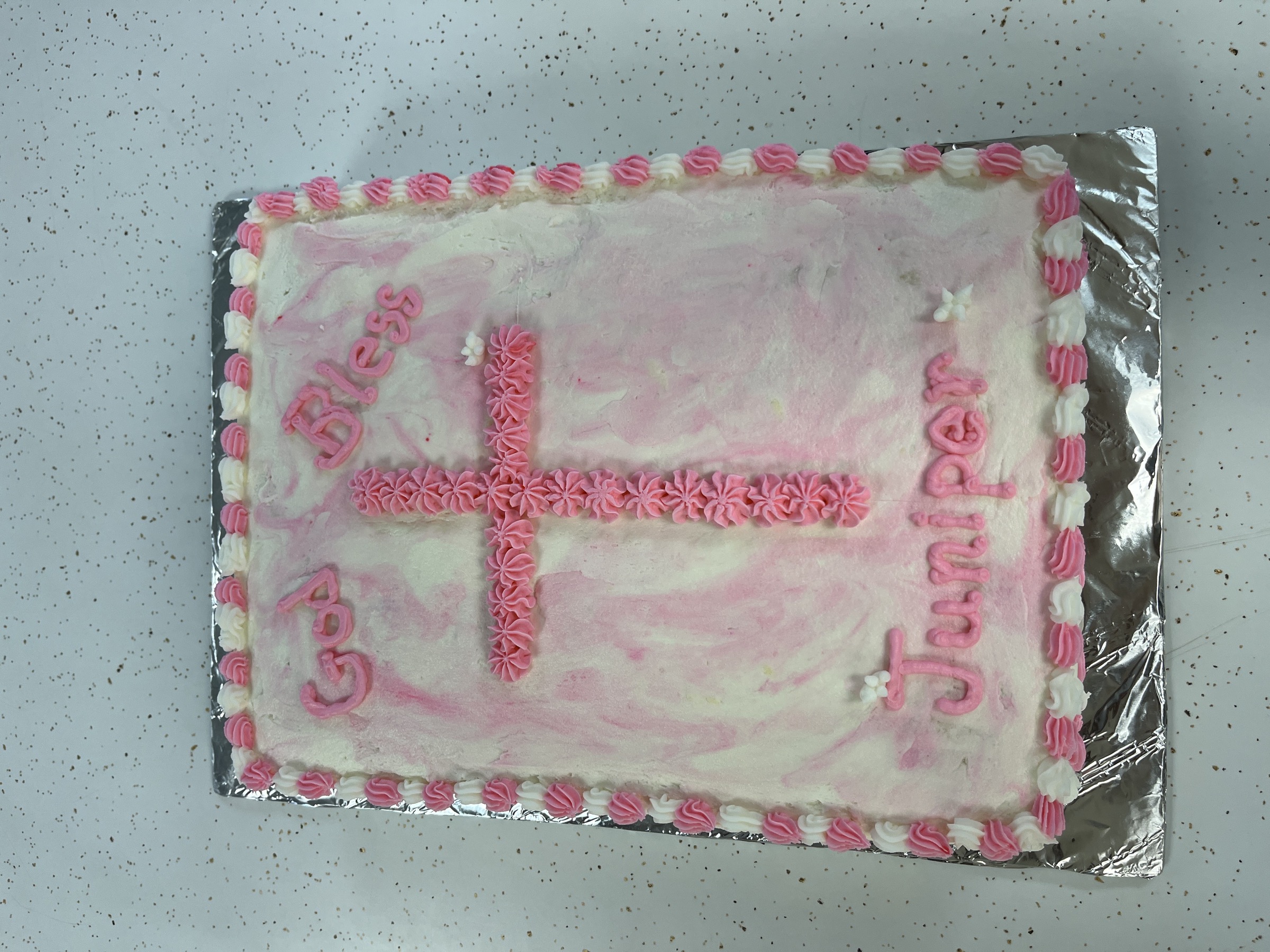 White and pink baptism sheet cake with piped cross and God Bless message